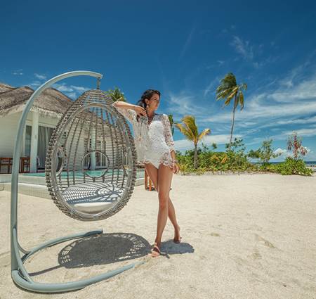 Lady striking a pose by the beach at Sun Siyam Iru Veli Maldives